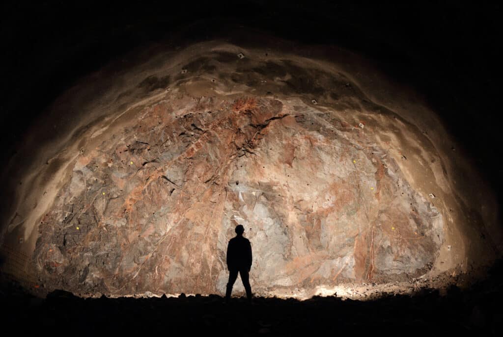 Man looking at large rock