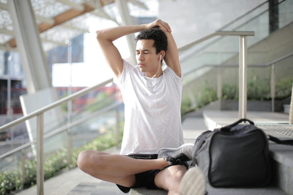 Man stretching while listening to audio